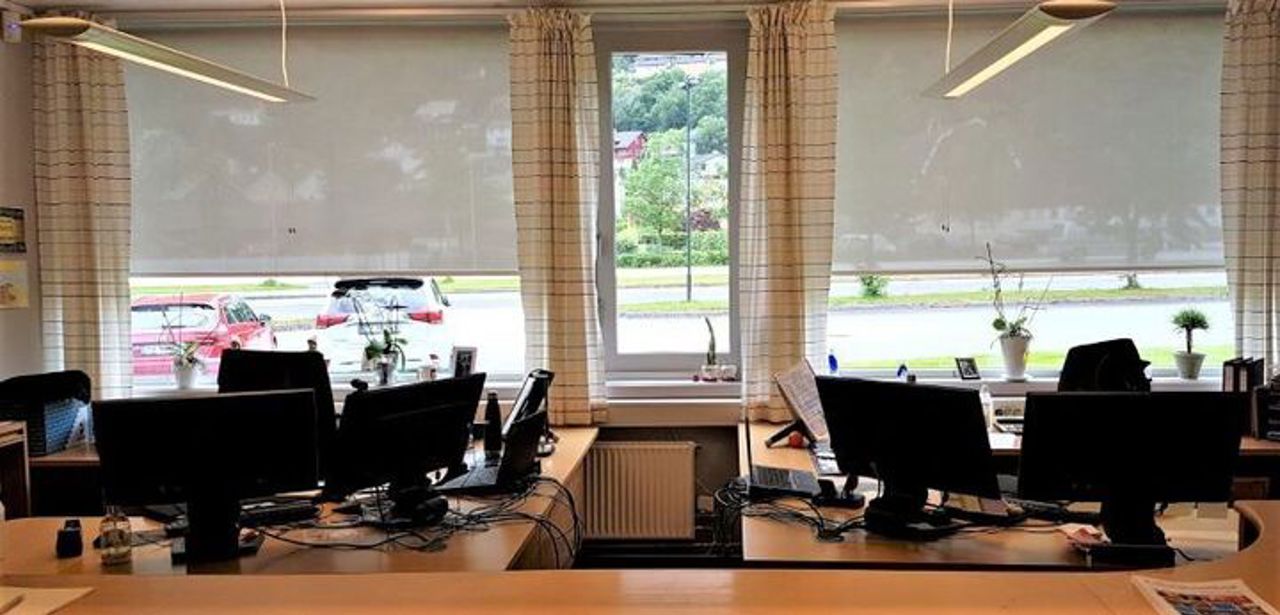 Bilete av to kontorplassar med fleire PC-skjermar