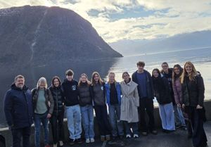 Elevar samlet på ei rekke med fjord og fjell i bakgrunnen